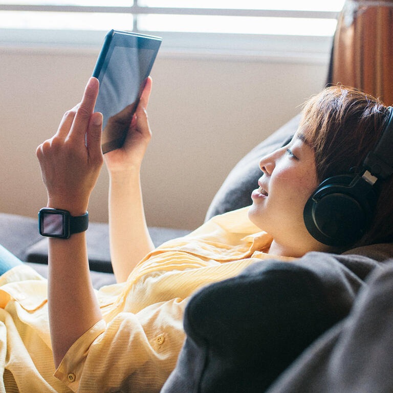 Femme tablette écouteurs montre connectée 